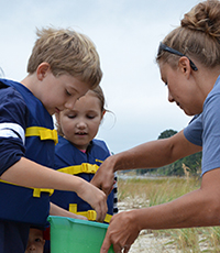 VIMS graduate student Kristene Parsons helps identify critters during the Bay Critters Beach Adventure program. Photo by Susan Maples-Luellen. 